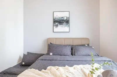 a bed in a bedroom with a picture on the wall at 4 mins to KLCC Luxurious Premium Suite in Three28 in Kuala Lumpur