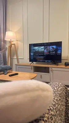 a living room with a tv on a stand with a table at Razak City Sunset HHhomestay 2R 2B Netflix Utube in Kuala Lumpur