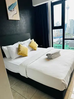 a bedroom with a large bed with yellow pillows at Crystal At Axon Residence KL in Kuala Lumpur