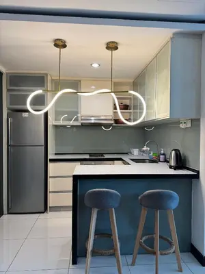 a kitchen with a blue counter and two stools at Bukit Bintang By Eryan Guest House in Kuala Lumpur