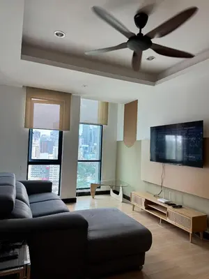 a living room with a couch and a ceiling fan at Bukit Bintang By Eryan Guest House in Kuala Lumpur