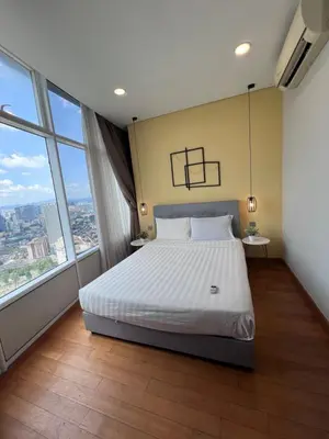 a bedroom with a large bed and large windows at SKY suits private room apartments in Kuala Lumpur