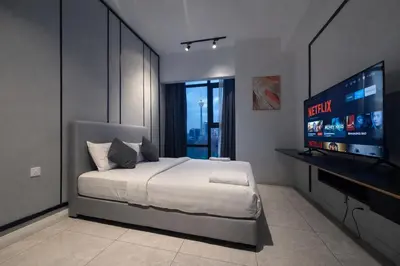 a bedroom with a bed and a flat screen tv at Axon Bukit Bintang By Sleeping Bird in Kuala Lumpur