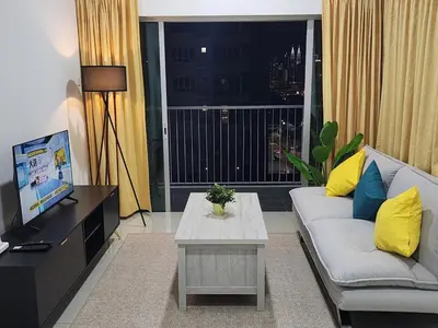a living room with a couch and a large window at Cozy Razak City 2B2B KLCC View Near KL Centre in Kuala Lumpur