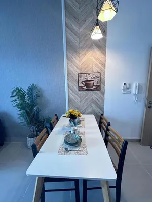 a white table with chairs and a vase of flowers on it at The Luxe KLCC By Serviced Apartment in Kuala Lumpur