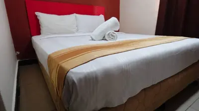 a bedroom with a large bed with a red headboard at Hotel Wings Kuala Lumpur in Kuala Lumpur
