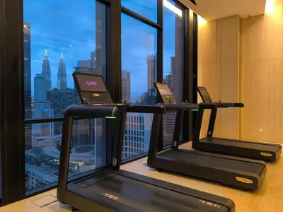 a gym with two treadmills in front of a window at Tour & Travel Malaysia Axon Residence Bukit Bintang KL in Kuala Lumpur
