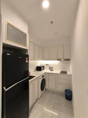 a kitchen with white cabinets and a black refrigerator at Tour & Travel Malaysia Axon Residence Bukit Bintang KL in Kuala Lumpur
