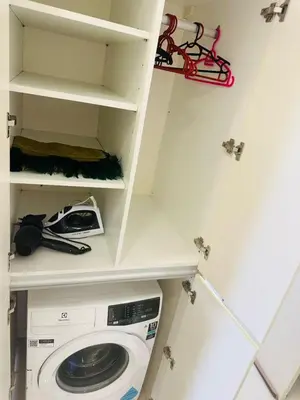 a laundry room with a washing machine and shelves at Cherry Homes at Chambers by Golden in Kuala Lumpur
