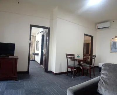 a hotel room with a table and a couch and a mirror at BTS apartment at times square in Kuala Lumpur