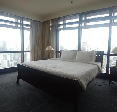 a bedroom with a large bed with large windows at BTS apartment at times square in Kuala Lumpur