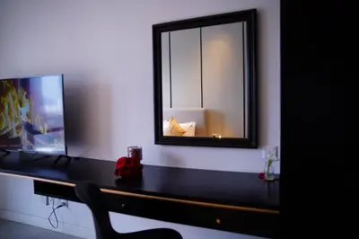 a mirror on a wall next to a desk with a chair at Axon Residence KLCC - CK Homestay in Kuala Lumpur