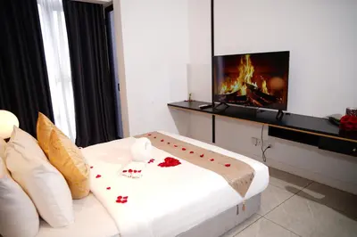 a room with a bed with a tv and a fireplace at Axon Residence KLCC - CK Homestay in Kuala Lumpur