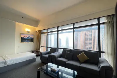 a hotel room with a couch and a bed and a large window at Signature Stay Times Square, Kuala Lumpur in Kuala Lumpur