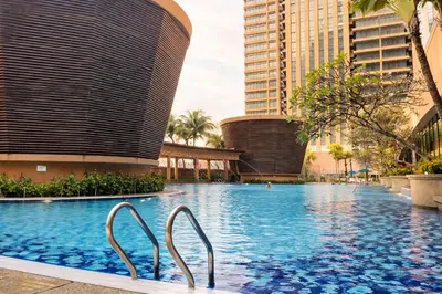 a swimming pool in the middle of a city with tall buildings at Signature Stay Times Square, Kuala Lumpur in Kuala Lumpur