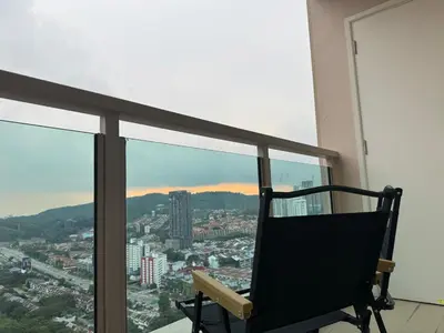 a chair on a balcony with a view of a city at Dorsett Hartamas with Rooftop Pool and Bathtub in KL City #215 in Kuala Lumpur