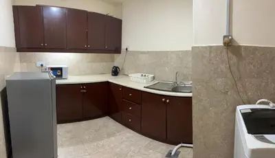 a kitchen with brown cabinets and a sink at Apartment TS at Times Square in Kuala Lumpur