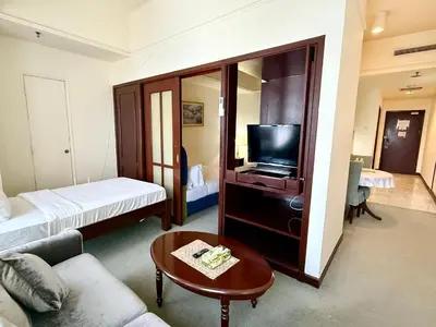 a living room with a couch and a television at Texas Service Suites At BTS Kuala Lumpur in Kuala Lumpur