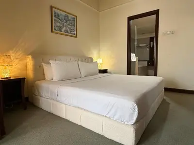 a bedroom with a large white bed and a mirror at Residential Family Apartments At Times Square KL in Kuala Lumpur
