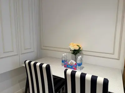 a table with two chairs and a vase of flowers at Axon Residence KLCC By Premium Suite in Kuala Lumpur