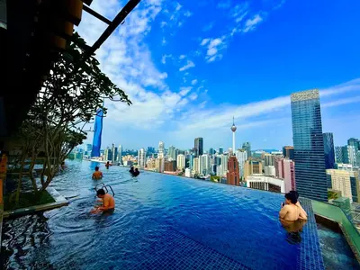 a group of people in a infinity pool with a city skyline at Axon Residence KLCC By Premium Suite in Kuala Lumpur