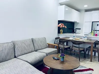 a living room with a couch and tables and a kitchen at Aurora Suites At Star Residences in Kuala Lumpur