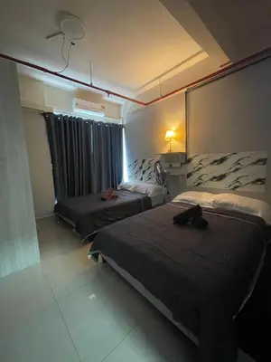 a hotel room with two beds and a window at Nour Homestay KLCC View - COMFORT in Kuala Lumpur