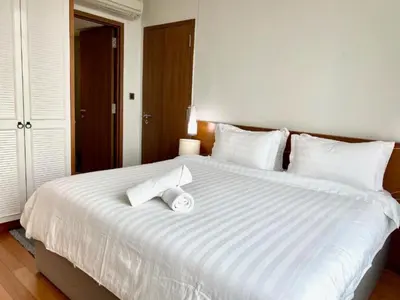 a bedroom with a large white bed with two towels on it at Sky Suites KLCC Luxury Cozy Suites in Kuala Lumpur