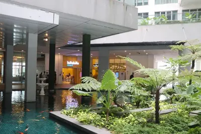 a lobby of a building with a pool of water and plants at Regalia SkyPool8 in Kuala Lumpur