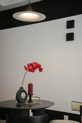 a table with a red flower in a vase on it at Cool Cityscape Homestay in KL City Center 1-5pax in Kuala Lumpur