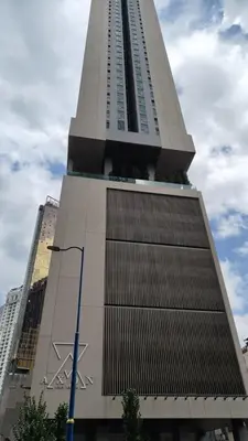 a tall building with a cross on the side of it at Axon premier suites, Pavilion Bukit bingtang, KL Tower in Kuala Lumpur