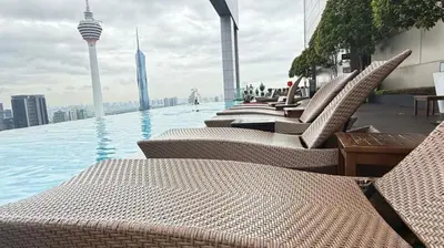 a row of chairs sitting on top of a building at The Platinum KLCC By Pool Point in Kuala Lumpur