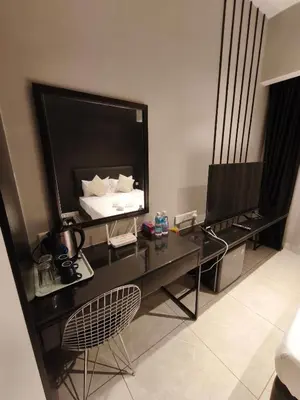 a room with a desk with a bed and a television at AXON RESIDENCE by DREAM HOME in Gua Sai