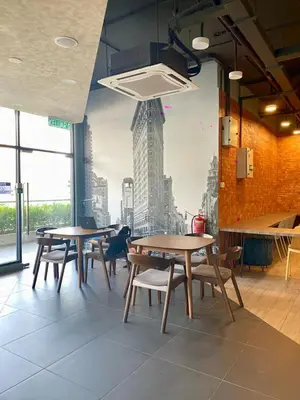 a restaurant with tables and chairs and a mural of a building at Neu Suites KLCC by HMM Home in Kuala Lumpur