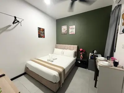 a bedroom with a bed and a green wall at Neu Suites Apartment - Cozy Modern Stay near KLCC in Kuala Lumpur
