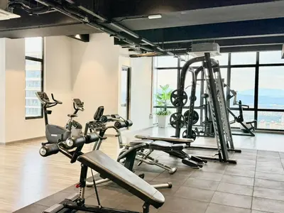 a gym with cardio equipment in a building with windows at The Manor Kuala Lampur in Kuala Lumpur