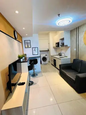 a living room with a couch and a kitchen at LUXE KLCC SKY LiNE in Kuala Lumpur