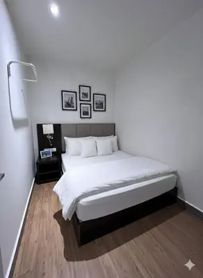 a bedroom with a large bed with white sheets at Amigo Petaling Street Kuala Lumpur in Kuala Lumpur