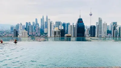 a infinity pool with a view of the singapore city at Regalia SkyLux Studio in Kuala Lumpur