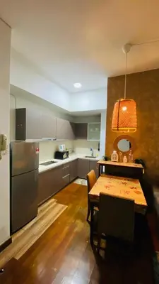 a kitchen with a table and a kitchen with a refrigerator at Regalia SkyLux Studio in Kuala Lumpur
