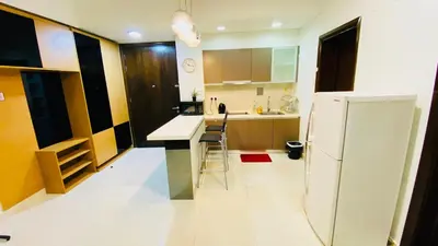 a kitchen with a white refrigerator and a counter at RegaliaA Residences in Kuala Lumpur