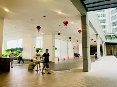 a group of people standing in a building with red lanterns at RegaliaA Residences in Kuala Lumpur
