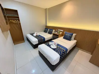 a hotel room with two beds and a table at Astarr Hotel KL in Kuala Lumpur