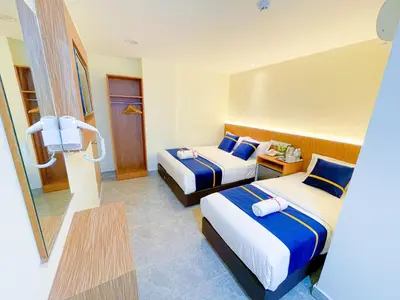 a hotel room with two beds and a table at Astarr Hotel KL in Kuala Lumpur