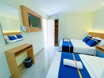 a hotel room with two beds and a television at Astarr Hotel KL in Kuala Lumpur