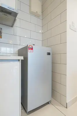 a white kitchen with a refrigerator and a counter at 9pax, Slide, RockClimbing, Arcade, near City & MITEC in Kuala Lumpur