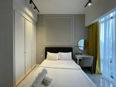 a bedroom with a bed and a table and a mirror at IKON SUITE's A X O N BUKIT BINTANG in Kuala Lumpur