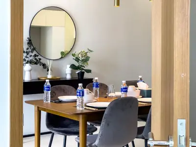 a dining room table with chairs and a mirror at SOHO SUITES KLCC BY Homestay in Kuala Lumpur