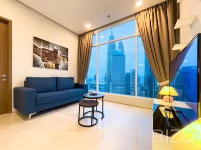 a living room with a blue couch and a large window at SOHO SUITES KLCC BY Homestay in Kuala Lumpur