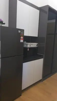 a kitchen with a black refrigerator and white cabinets at The Colony Infinitum KLCC Suits By Saidul in Kuala Lumpur